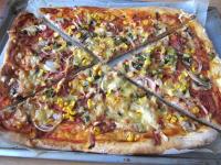 Pizza warm servieren, in Dreieck geschnitten. ...