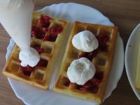 Begossene Waffeln mit Sahne und Erdbeerhälften...
